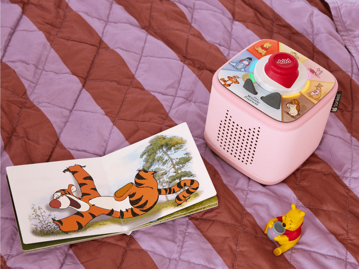 child playing with pink Toniebox 2, tonieplay controller, Winnie the Pooh tonie and disney tonieplay game