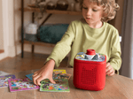 Child playing with a red Toniebox 2 an audio player for kids with monster talent search tonieplay
